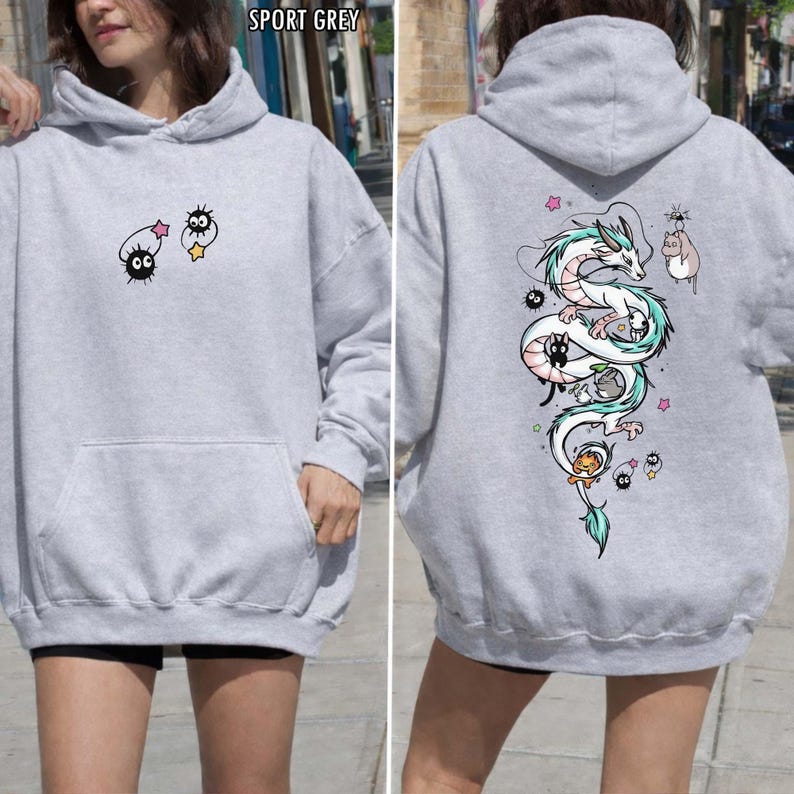Pode incluir: Moletom cinza esportivo com bolso frontal e capuz. A frente apresenta um desenho de desenho animado de duas criaturas pretas com estrelas. A parte de tr&aacute;s exibe uma ilustra&ccedil;&atilde;o de drag&atilde;o branco e turquesa com outros personagens de desenho animado.