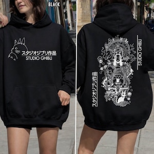 May include: Black Studio Ghibli hoodie with a front pocket and hood. The front features a white illustration and Japanese text. The back displays a detailed white graphic of characters and Japanese text, with "STUDIO GHIBLI" printed vertically.