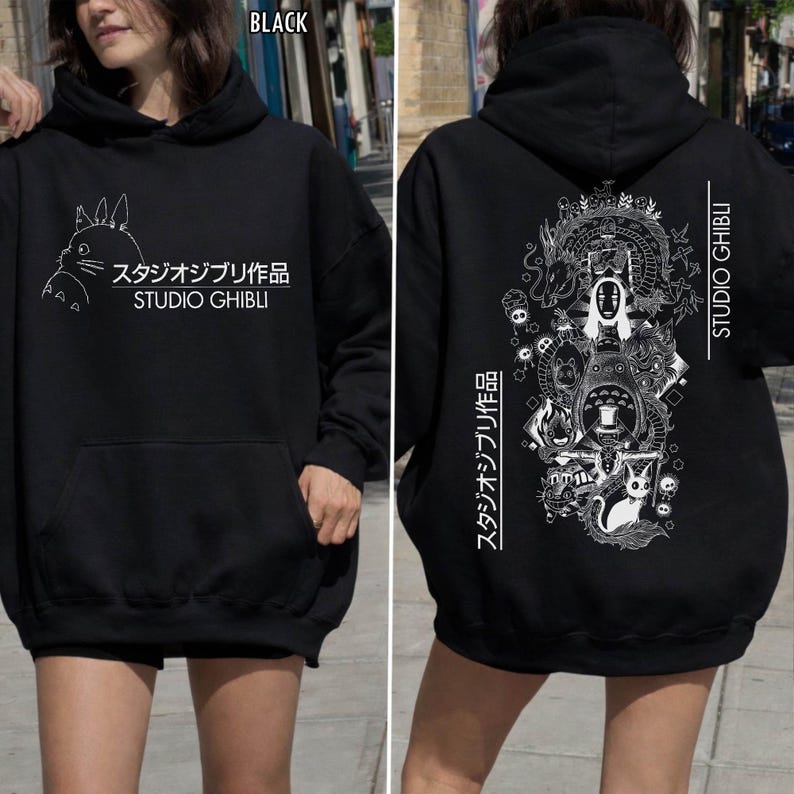 May include: Black Studio Ghibli hoodie with a front pocket and hood. The front features a white illustration and Japanese text. The back displays a detailed white graphic of characters and Japanese text, with "STUDIO GHIBLI" printed vertically.