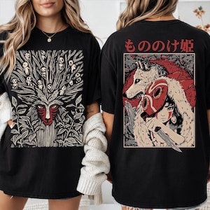 Może przedstawiać: Czarne koszulki z grafiką w stylu anime. Jedna koszulka przedstawia projekt ducha lasu, druga postać z wilkiem i japońskim tekstem "Mononoke Hime".