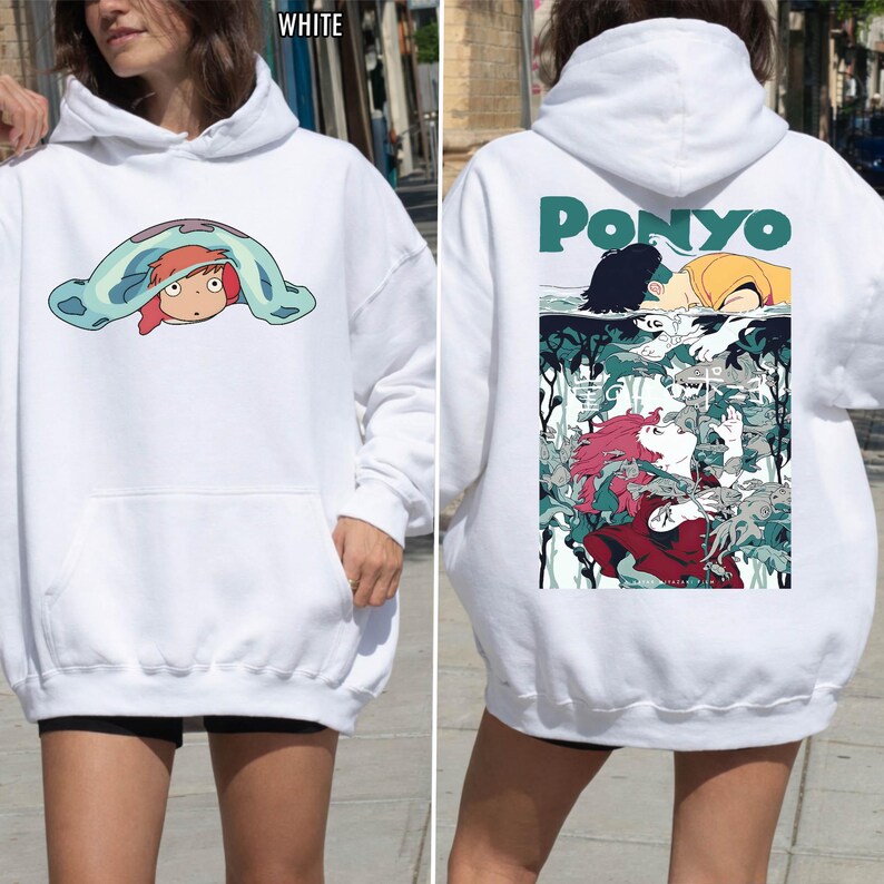 May include: White hoodie featuring a front graphic of a cartoon character under a blue blanket. The back of the hoodie displays the word "PONYO" in green, along with a colorful illustration of characters from the animated film.