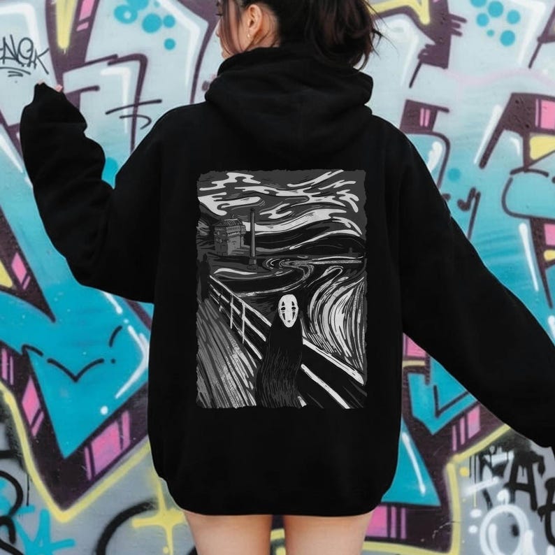 Op de afbeelding: Zwarte hoodie met een grijswaardenafbeelding van een figuur uit de animatiefilm Spirited Away, ge&iuml;nspireerd op Edvard Munchs "De Schreeuw". Het ontwerp staat op de achterkant van de hoodie.