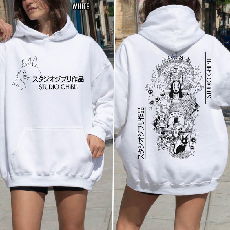 May include: White hoodie featuring a front graphic of a cartoon character and Japanese text, "スタジオジブリ作品 STUDIO GHIBLI." The back displays a detailed black and white illustration with Japanese text and "STUDIO GHIBLI."