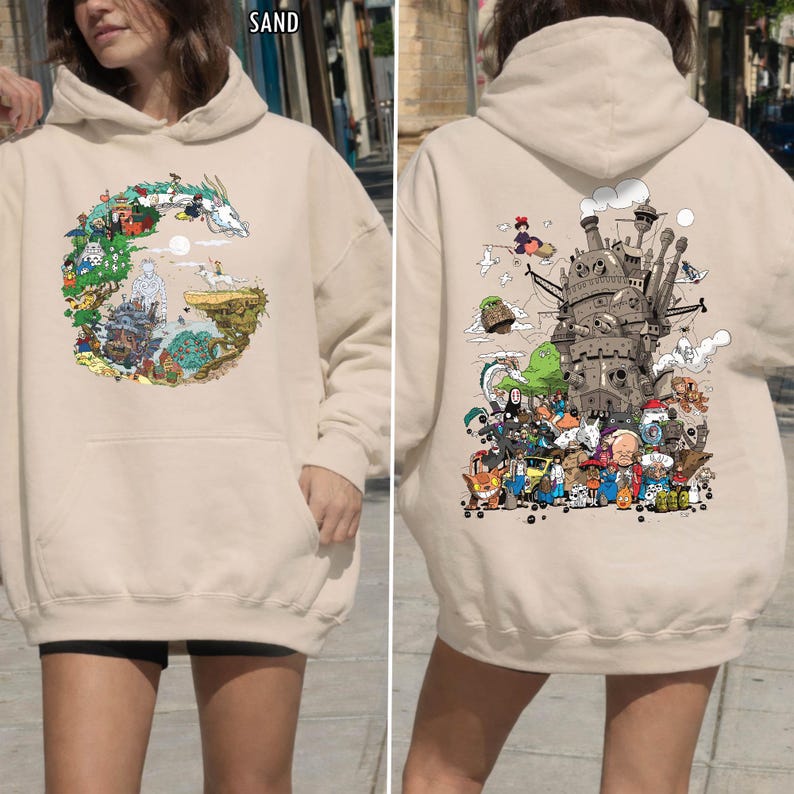May include: Sand-coloured hoodie with a colourful graphic on the front and back. The front graphic depicts a circular scene with a dragon and other characters. The back graphic shows a castle and various animated characters. The hoodie has a hood and a front pocket.