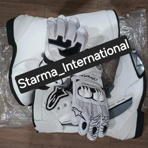 Puede incluir: Botas y guantes de moto blancos. Las botas tienen suelas y detalles negros, con un detalle plateado en el lateral. Los guantes son blancos con detalles en negro y gris. El texto "Starma_International" está en la imagen.