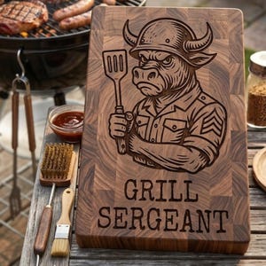 May include: A wooden cutting board with a carved illustration of a bull wearing a helmet and military uniform, holding a spatula. The text "GRILL SERGEANT" is below the image. The board is next to a grill with food.