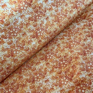 Könnte beinhalten: Nahaufnahme eines Stoffes mit einem sich wiederholenden Blumenmuster in Orange- und Cremetönen. Das Design zeigt stilisierte Blumen und Blätter mit einer gepunkteten Textur, die eine Vintage- oder rustikale Ästhetik erzeugt. Der Stoff ist gefaltet und zeigt seine Textur und Tiefe.