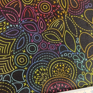 Könnte beinhalten: Schwarzer Stoff mit einem farbenfrohen Stickmuster. Das Muster zeigt abstrakte Blumen- und geometrische Formen, die mit neon-gelben, rosa, blauen und grünen Nähten umrandet sind. Ein Lineal liegt unten.