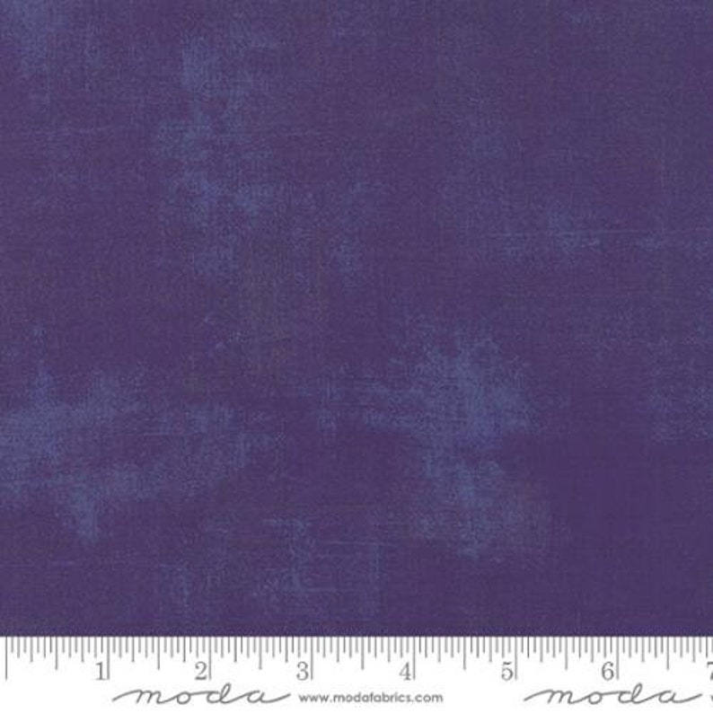 May include: Purple fabric with a subtle textured pattern. The fabric has a slightly distressed look, with a faded blue color throughout. The fabric is measured in inches.