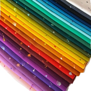 Könnte beinhalten: Ein Stapel von 24 Stoffquadraten mit einem Regenbogenfarbverlauf. Jedes Quadrat hat ein anderes Muster aus kleinen, bunten Formen. Der Stoff ist eine weiche Baumwollmischung. Der Text "toll PAICHig" ist am unteren Rand des Bildes sichtbar.