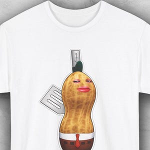 May include: A white ceramic mug with a black handle and the text "But First, Coffee" in a bold, black font. The mug is set against a blurred background, suggesting a cozy setting.