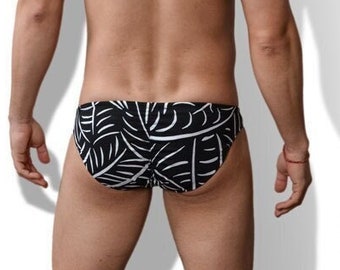 May include: Black and white patterned swim trunks with a tropical leaf design.