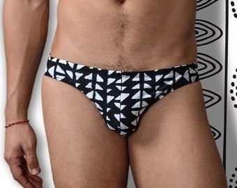 May include: A black and white patterned swimsuit with a geometric design. The swimsuit is low-rise and has a cheeky cut.