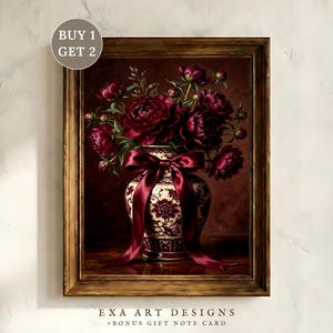 May include: A framed painting of a vase filled with burgundy peonies. The vase is white with a red floral pattern and a burgundy ribbon. The painting is in a wooden frame. The text "EXA ART DESIGNS +BONUS GIFT NOTE CARD" is at the bottom.