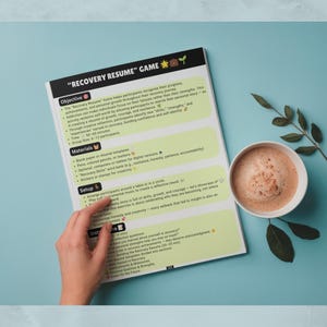 May include: A printed document titled "RECOVERY RESUME" GAME with sections for Objective, Materials, Setup, and Instructions. The page features light green text boxes on a white background, accented with small icons and emojis.