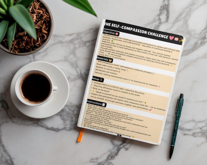 May include: A white notebook titled The Self-Compassion Challenge with black text and peach-coloured sections. The page outlines objectives, materials, setup, and instructions for a group activity. A black pen rests beside the notebook.