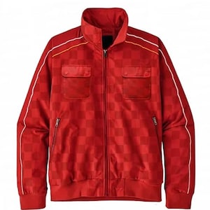 May include: Red track jacket with a checkered pattern. Features a high collar, two front pockets, and a full-length zipper. White and yellow stripes accent the shoulders and sleeves. Ribbed cuffs and hem complete the design.