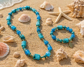 Puede incluir: Un conjunto de collar y pulsera de cuentas con abalorios rectangulares y redondos de color turquesa y pequeños espaciadores metálicos. La pulsera incluye un pequeño dije dorado en forma de mano de hamsa colgando.