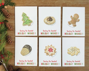 May include: Six holiday greeting cards with illustrated cookies and the text "Sending the Sweetest HOLIDAY WISHES!" on each card. The cookies include a gingerbread man, a chocolate-filled cookie, a star-shaped cookie, a tree-shaped cookie, a swirl cookie, and a muffin-shaped cookie.