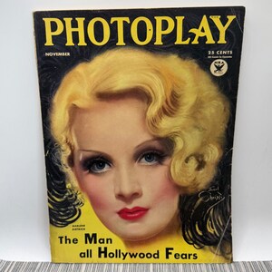 May include: Vintage Photoplay magazine cover featuring Marlene Dietrich. The cover has a yellow background with the title "PHOTOPLAY" in large yellow letters. The cover also includes the text "The Man all Hollywood Fears".
