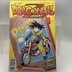 May include: A vintage Dragon Ball Z comic book. The cover features Goku riding a red motorcycle with the number 12. The title "Dragon Ball Z" is in large orange letters. The comic is published by VIZ Comics.