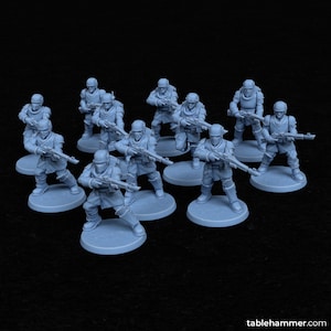 Könnte beinhalten: Eine Ansammlung hellblauer Miniatursoldaten, die jeweils ein Gewehr halten. Die Figuren stehen auf kreisförmigen Sockeln und tragen Helme und Rüstungen. Der Hintergrund ist schwarz.