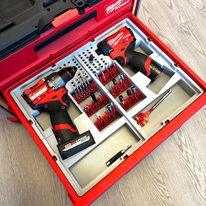 Peut inclure: Mallette à outils rouge et noire avec une variété d'embouts et d'accessoires. Le kit comprend deux perceuses, une sélection de mèches et d'autres outils, le tout soigneusement organisé dans un étui rouge et gris.
