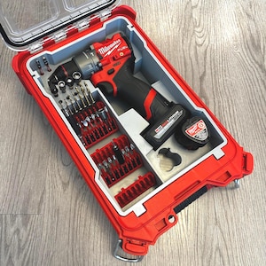 May include: A red tool case with a clear lid, housing a red and black drill, drill bits, and accessories. The drill is labelled "Milwaukee FUEL". The case is open, displaying the organised contents.