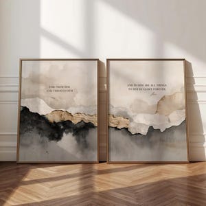May include: Two framed art prints with gold frames. Each print features an abstract watercolour landscape in neutral tones of beige, grey, and black. The prints include the text "FOR FROM HIM AND THROUGH HIM" and "AND TO HIM ARE ALL THINGS TO HIM BE GLORY FOREVER."