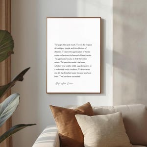 Puede incluir: Una impresi&oacute;n enmarcada con un marco de madera marr&oacute;n cuelga de una pared blanca. La impresi&oacute;n presenta texto negro sobre un fondo blanco, una cita de Ralph Waldo Emerson. La impresi&oacute;n est&aacute; encima de un sof&aacute; beige con cojines marrones y beiges.