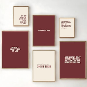 Könnte beinhalten: Eine Sammlung gerahmter Kunstdrucke mit inspirierenden Zitaten im minimalistischen Stil. Die Drucke zeigen Text in einer Serifenschrift auf bordeauxroten und cremefarbenen Hintergründen mit goldenen Rahmen. Die Zitate enthalten Sätze wie "Spoiled by God" und "Heavily Protected by God."