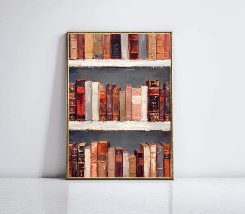 K&ouml;nnte beinhalten: Gerahmtes Kunstwerk mit einem B&uuml;cherregal voller alter B&uuml;cher. Die B&uuml;cher in verschiedenen Farben wie Rot, Braun und Creme sind auf drei wei&szlig;en Regalen vor einem dunkelgrauen Hintergrund angeordnet. Der Rahmen ist goldfarben.