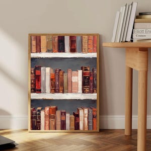 K&ouml;nnte beinhalten: Ein gerahmtes Kunstwerk, das ein B&uuml;cherregal mit alten B&uuml;chern zeigt. Die B&uuml;cher sind in verschiedenen Farben gehalten, darunter Rot, Braun und Beige. Das Kunstwerk hat einen Holzrahmen und wird vor einer neutralen Wand pr&auml;sentiert.