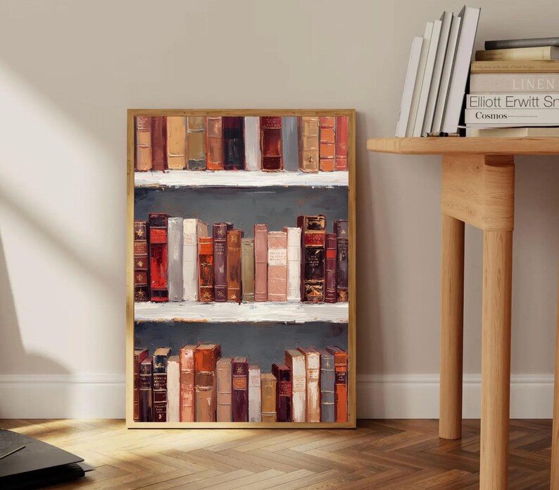 K&ouml;nnte beinhalten: Ein gerahmtes Kunstwerk, das ein B&uuml;cherregal mit alten B&uuml;chern zeigt. Die B&uuml;cher sind in verschiedenen Farben gehalten, darunter Rot, Braun und Beige. Das Kunstwerk hat einen Holzrahmen und wird vor einer neutralen Wand pr&auml;sentiert.