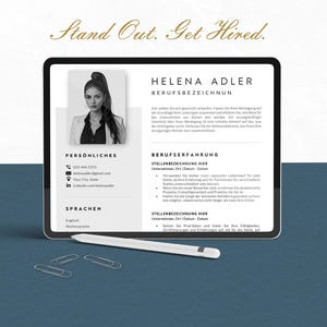 May include: A digital tablet displaying a resume template with the name "Helena Adler" and the text "Stand Out. Get Hired." A stylus and paper clips are on the surface. The resume includes personal and professional experience sections.
