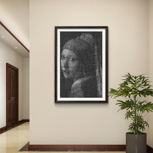 May include: A framed wall art print featuring a black and white portrait created with dense, overlapping scribbled lines. The artwork depicts a person wearing a headscarf, rendered in a dark, textured style within a simple black frame on a wall.