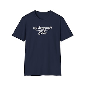 Peut inclure: T-shirt bleu marine avec le texte blanc "my hovercraft is full of Eels". Le texte est écrit dans une police stylisée. Le t-shirt est à col rond et à manches courtes.