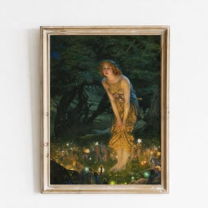 Op de afbeelding: Een ingelijste kunstdruk met een centrale figuur met lang roodachtig haar in een gouden jurk, staand in een donkere bosrijke open plek, omringd door talloze kleine, lichtgevende figuren bij de grond tussen het gras en de bomen.