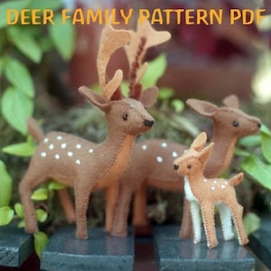 May include: A set of three felt deer, a large brown deer with antlers, a medium brown deer, and a small fawn. The deer are all standing on a dark surface.