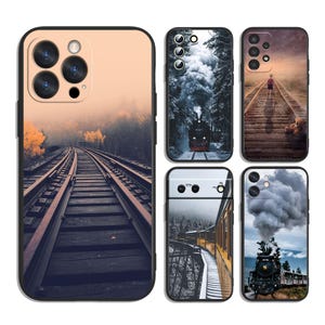 May include: Five rectangular smartphone cases featuring various printed designs of trains, railway tracks, and steam. The designs include a train on tracks in fog, a steam locomotive in a forest, a person on tracks with a teddy bear, and a train in snow.