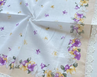 Pañuelo vintage de algodón ligero de Nina Ricci, con delicadas violetas, flores amarillas, detalles de mariposas y un elegante borde de encaje.