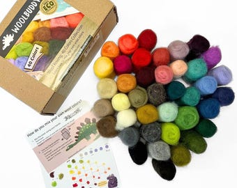 Peut inclure: Une boîte de 40 couleurs de laine cardée, avec une variété de couleurs, dont le rouge, l'orange, le jaune, le vert, le bleu, le violet et le marron. La boîte est étiquetée "Wool Roving: 40 Colors Collection" et "Apprenez à mélanger vos propres couleurs de laine".