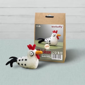 May include: A Woolbuddy needle felting kit for a chicken, featuring a white felted chicken with black spots, a red comb and wattle, and an orange beak. The brown paper packaging displays the finished chicken, the text Chicken, and a barcode.