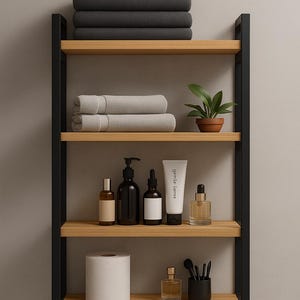 May include: A contemporary bathroom shelf unit with black metal supports and wooden shelves. The shelves display folded grey towels, toiletries, a small potted plant, and a roll of toilet paper. The unit is against a neutral wall.