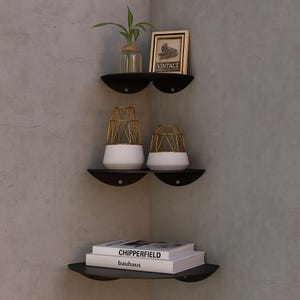 May include: Black corner shelves with decorative items. The top shelf holds a small framed picture with the word "VINTAGE" and a glass vase with a plant. The middle shelf has two white and gold geometric vases. The bottom shelf displays two books.