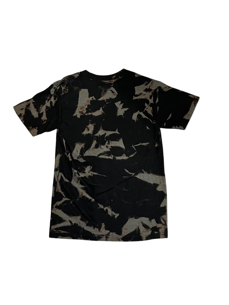 May include: Black t-shirt with a tie-dye pattern in shades of gray and black.