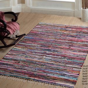 Könnte beinhalten: Ein bunter, mehrfarbiger Teppich mit Fransen an den Rändern. Der Teppich ist aus recycelten Materialien hergestellt und in verschiedenen Größen erhältlich, darunter 50x80 cm, 60x90 cm, 60x200 cm, 70x140 cm, 90x150 cm, 120x180 cm, 150x240 cm und 183x274 cm.