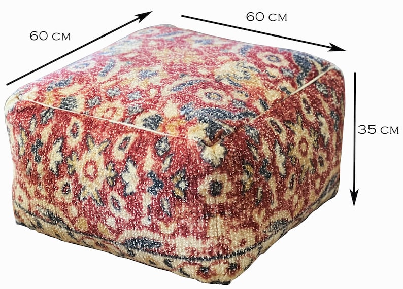 Może przedstawiać: Kwadratowa pufa z wzorem w kolorze czerwonym, beżowym i granatowym. Pufa ma wymiary 60 cm z każdej strony i 35 cm wysokości. Tkanina ma teksturowany wygląd.