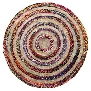 May include: A round jute rug with a spiral design. The rug features concentric circles of natural beige jute and colorful braided accents in red, orange, blue, purple, and green. The rug is suitable for indoor use.