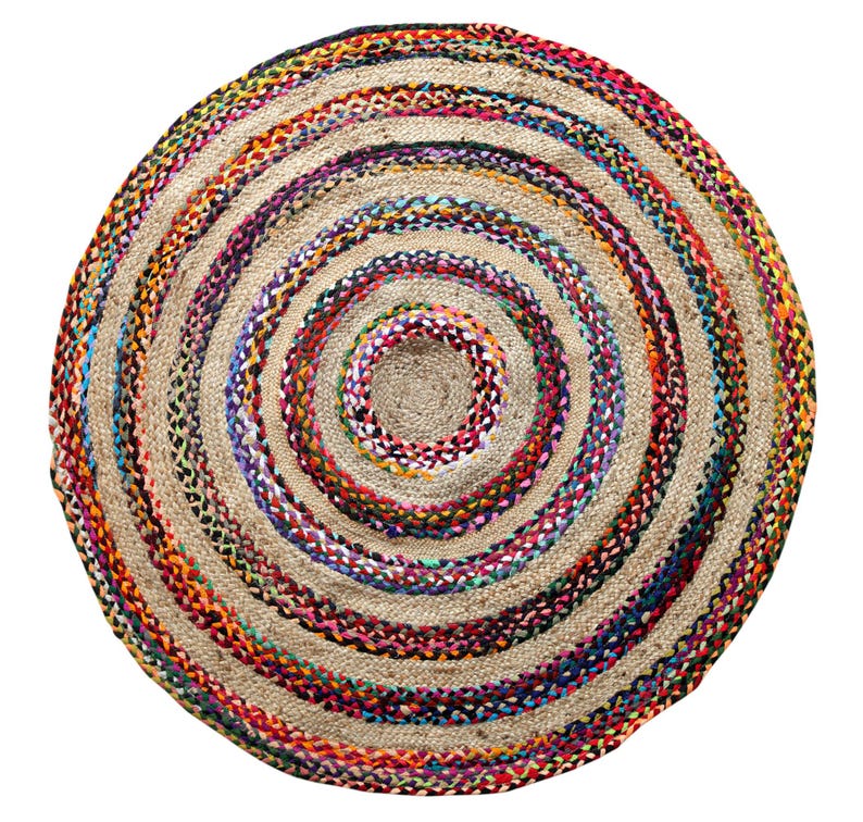 May include: A round jute rug with a spiral design. The rug features concentric circles of natural beige jute and colorful braided accents in red, orange, blue, purple, and green. The rug is suitable for indoor use.